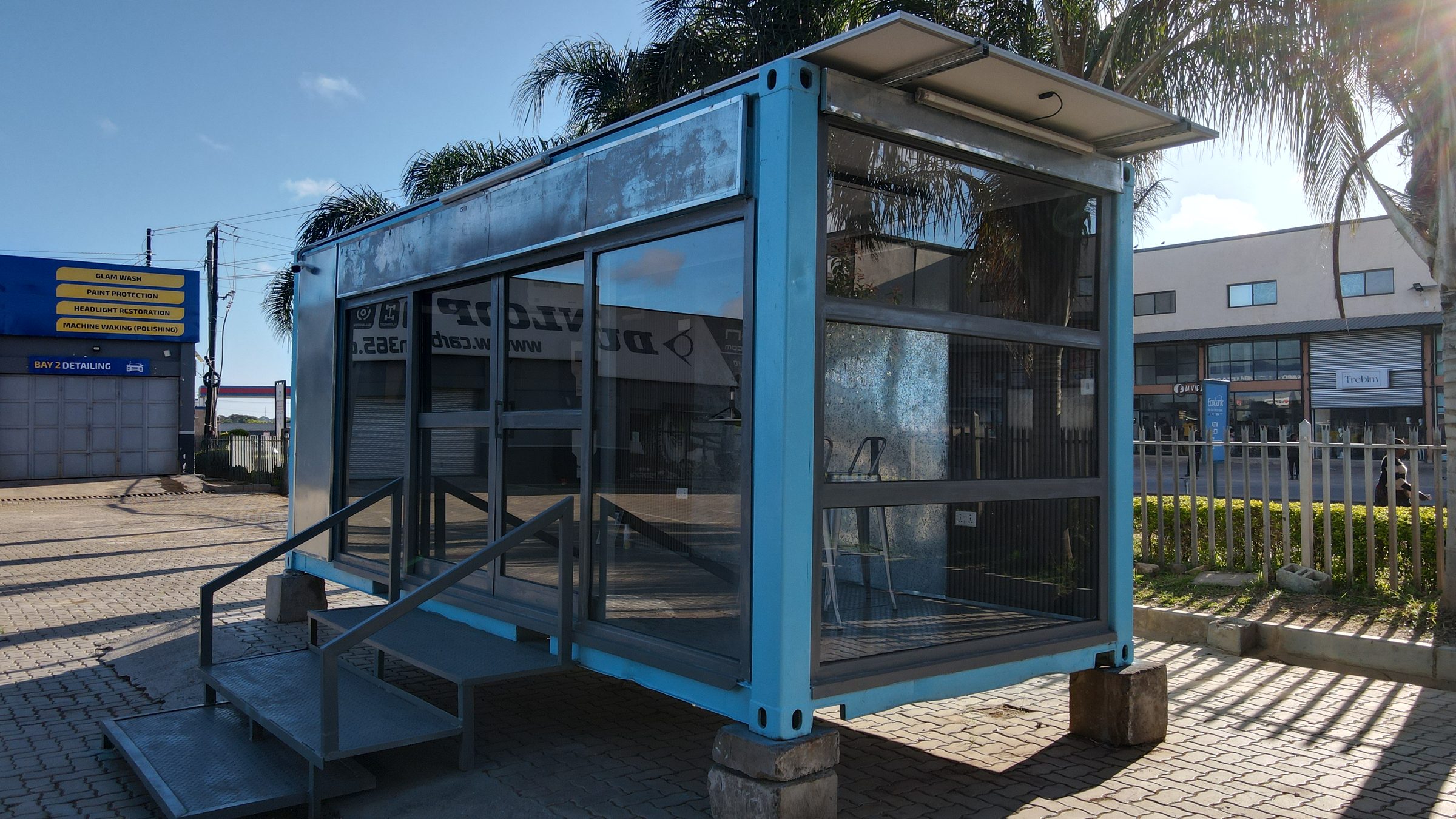 Blue container kiosk with full glazing, fabricated by MEIT